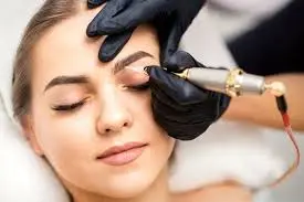 Beautician applying pigment to eyebrows during microblading procedure